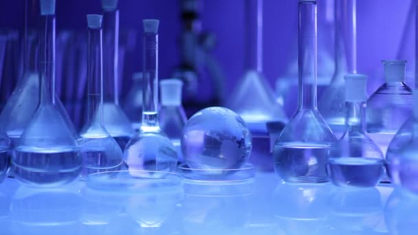 Moderne laboratoriumapparatuur, set van verschillende glaswerk op blauwe achtergrond. Dolly schot. - Video