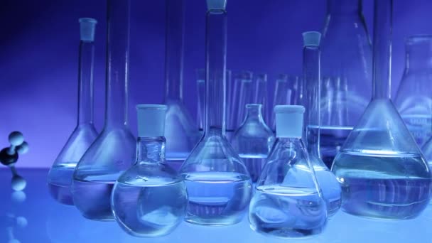 Équipement de laboratoire moderne, ensemble de verrerie différente sur fond bleu. Dolly shot
. - Séquence, vidéo