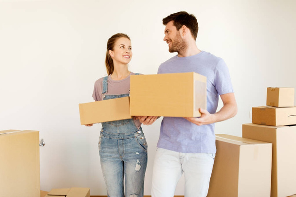 счастливая пара с коробками переезжают в новый дом - Фото, изображение