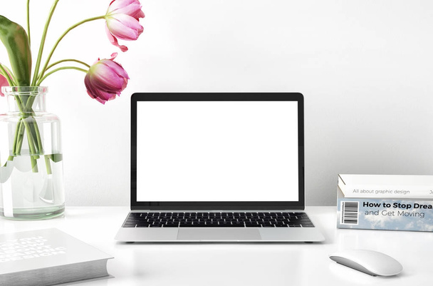 computer portatile con fiori in vaso e libri su desktop
  - Foto, immagini