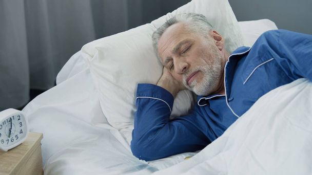 Aged male sleeping in bed in the morning, healthy sleep, recovery time, closeup - Photo, Image