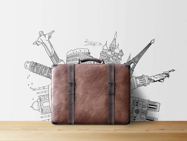 brown valise with sketch of popular tourist attractions on wall, travel concept  - Photo, Image