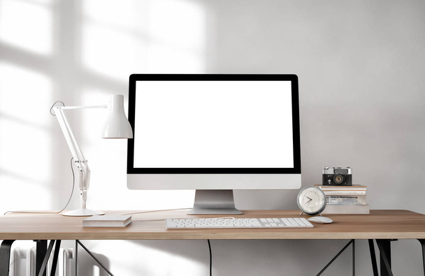 weißer leerer Computerbildschirm mit Tischlampe und Büchern auf dem Schreibtisch     - Foto, Bild