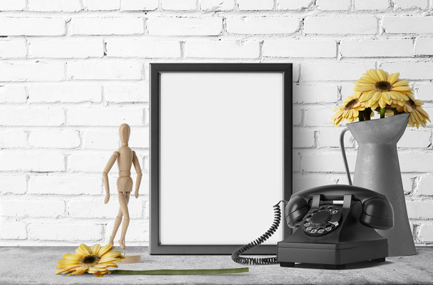 marco de fotos vacío con margaritas amarillas en jarra de jardín de metal y teléfono retro
 - Foto, Imagen