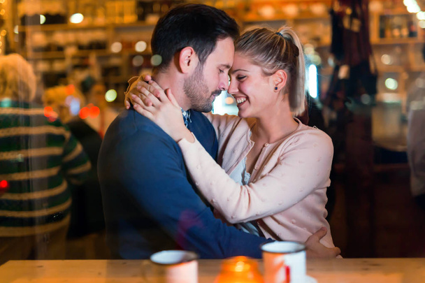 Happy couple hugging at bar and having date - Фото, зображення