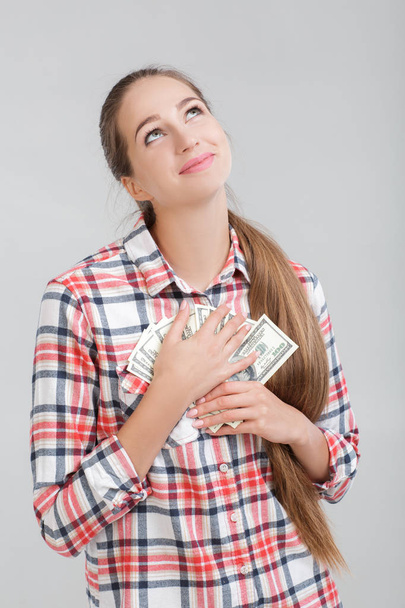 woman in a plaid shirt holding dollar bills. - Valokuva, kuva