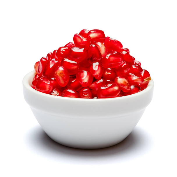 Pomegranate seeds in ceramic bowl close-up - Фото, изображение
