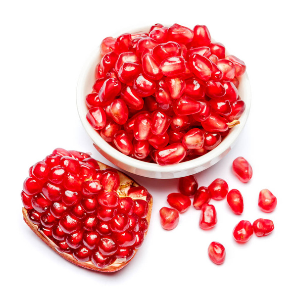 Pomegranate and seeds in ceramic bowl close-up - Фото, изображение