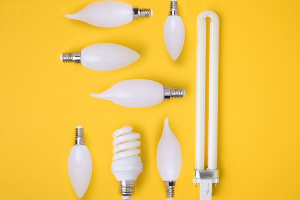 top view of set of various white lamps isolated on yellow - Zdjęcie, obraz