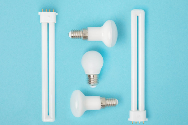 flat lay with arranged various light bulbs isolated on blue - Foto, Imagem