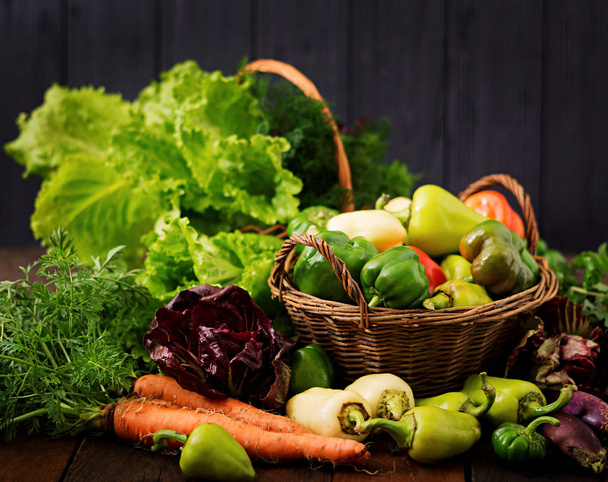 野菜と緑ハーブの品揃え。市場。暗い背景にバスケットの野菜 - 写真・画像