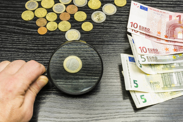 Одна монета евро через лупу
. - Фото, изображение