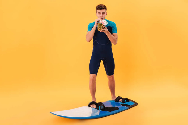 Image of Smiling surfer in wetsuit using surfboard - Zdjęcie, obraz