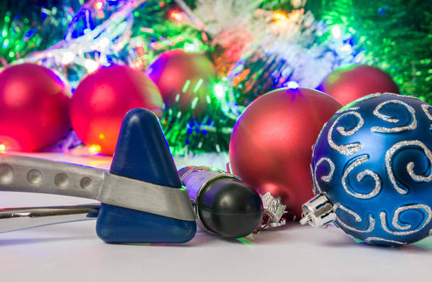 Natale e Capodanno in neurologia, medicina o neuroscienze foto - due martello neurologico si trovano vicino alle palle per l'albero di Natale in sfondo sfocato con ghirlande elettriche luci e giocattoli
 - Foto, immagini