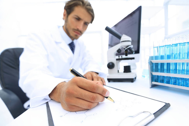 scientist makes a note of experiment in the laboratory - Фото, изображение