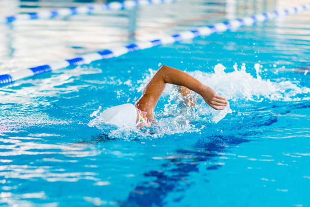 Женщина-пловец на тренировке в бассейне. Передний стиль плавания
 - Фото, изображение