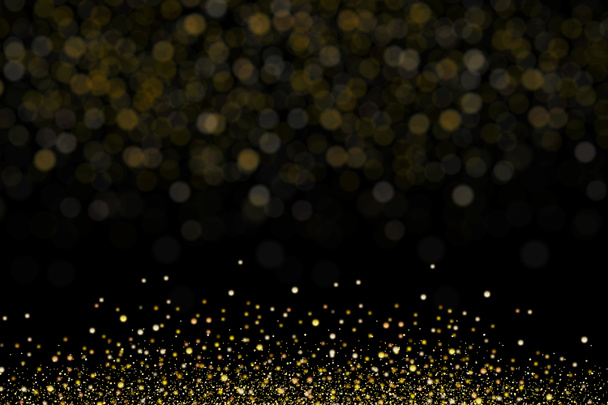 Goud glitter, sneeuwt van korrelige deeltjes. Explosie van feestelijke confetti met bokeh effect. Overlay textuur, geïsoleerd op zwarte achtergrond    - Foto, afbeelding
