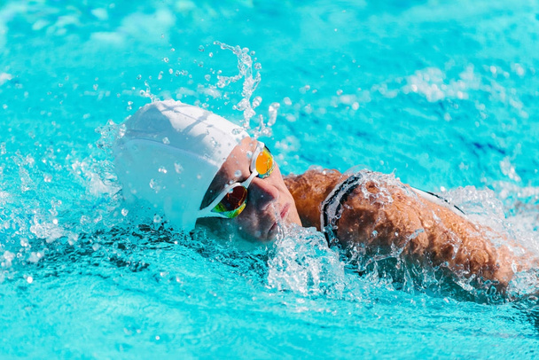Uimarinainen treenaa uima-altaassa. Edessä indeksointi uinti tyyli
 - Valokuva, kuva