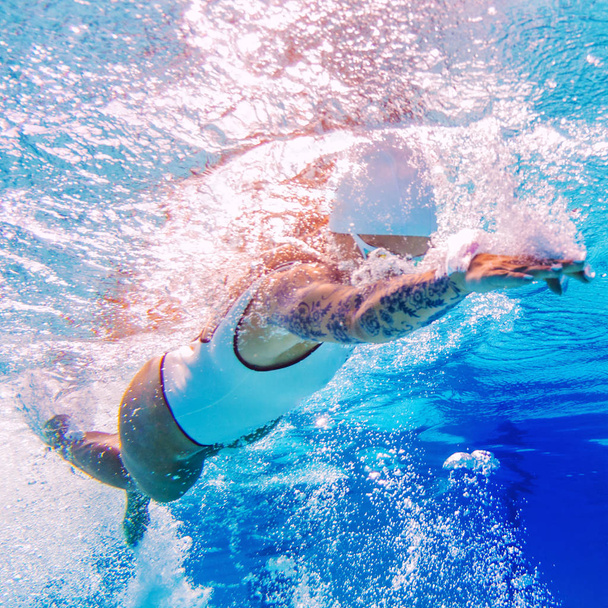 Female swimmer with tattoos. Underwater shoot - Foto, immagini