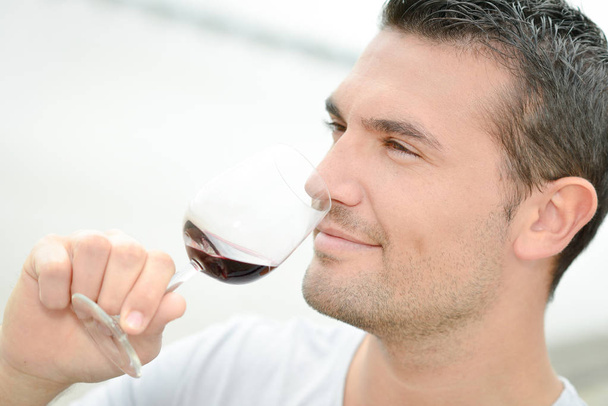 Man δοκιμάζοντας λίγο κόκκινο κρασί - Φωτογραφία, εικόνα