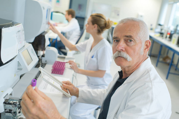 senior doctor examines a medical record in the hospital room - Foto, Bild
