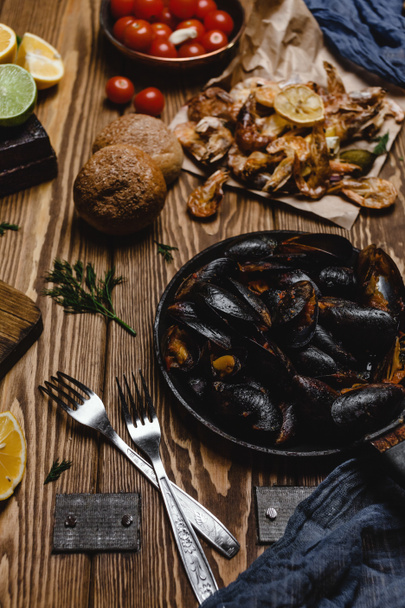 Assorted cooked seafood with bread and tomatoes on wooden table - Foto, Imagem