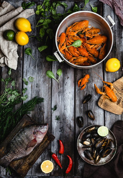 top view of various delicious seafood with lemons and herbs on rustic wooden table  - Fotografie, Obrázek