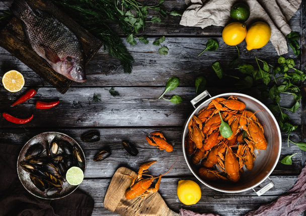Blick von oben auf verschiedene köstliche Meeresfrüchte auf rustikalem Holztisch  - Foto, Bild