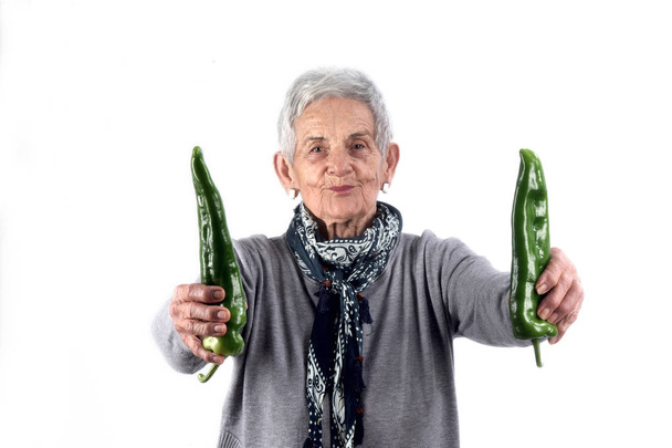 Starší žena jíst pepř na bílém - Fotografie, Obrázek
