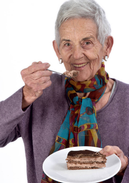 Donna anziana mangiare un pezzo di torta
 - Foto, immagini