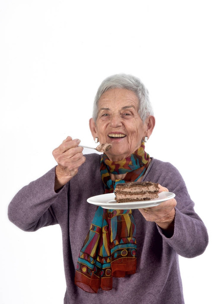 Vanhempi nainen syö pala kakkua
 - Valokuva, kuva