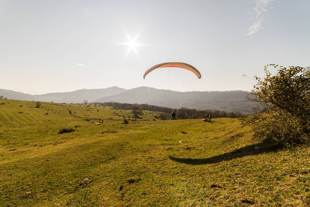 a young girl flies on a paraglider far out of town on vacation - Фото, изображение