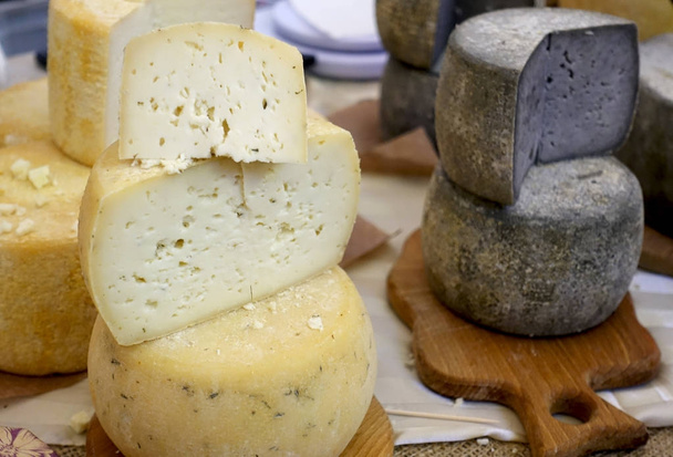 Näkymä koko ja lovinen päät erilaisia juustoja tiskillä
.                                      - Valokuva, kuva
