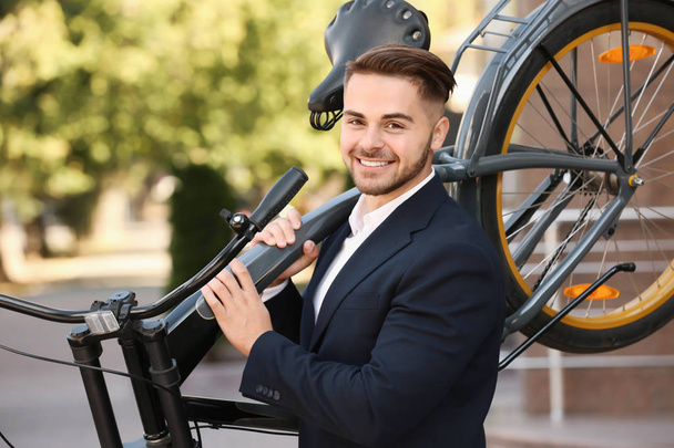 Young handsome businessman holding bicycle outdoors - Φωτογραφία, εικόνα