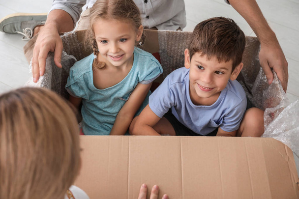 Kinder spielen nach Umzug in neue Wohnung mit Karton - Foto, Bild