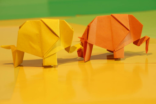 折り紙のゾウ。多色の背景上の色紙の象。日本の美術. - 写真・画像