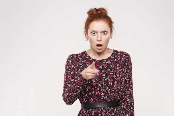 seriously redhead woman wearing flowers dress pointing finger at camera    - Photo, image