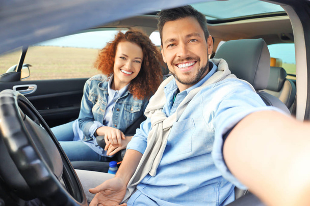 Happy young couple taking selfie in car - Foto, immagini