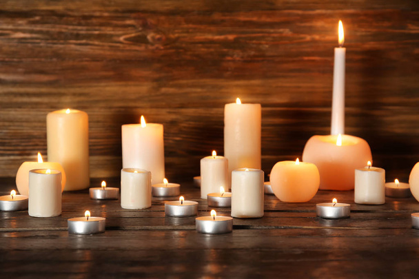 Many burning candles on wooden background - Photo, Image