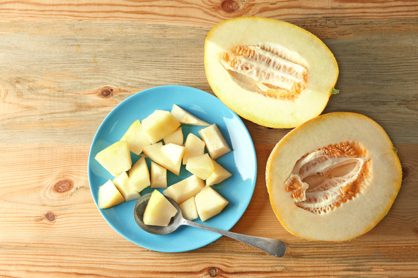 Plate with yummy melon on wooden table - Φωτογραφία, εικόνα