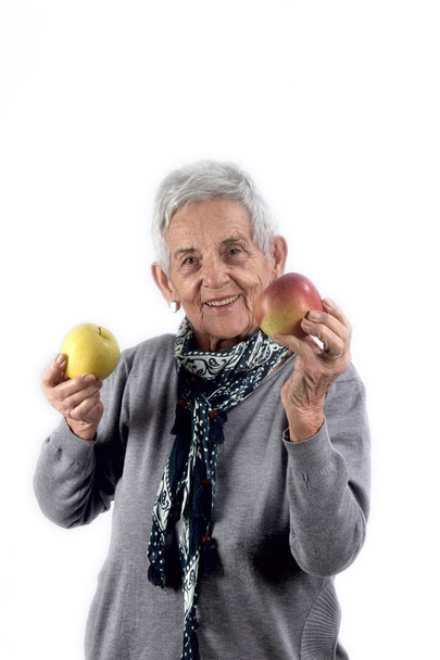 пожилая женщина ест яблоко на белом
 - Фото, изображение