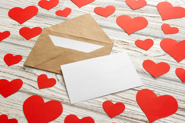 Harten vliegen uit van de envelop. Liefdesbrief. Dag van de Valentijnskaart van de achtergrond op houten achtergrond - Foto, afbeelding