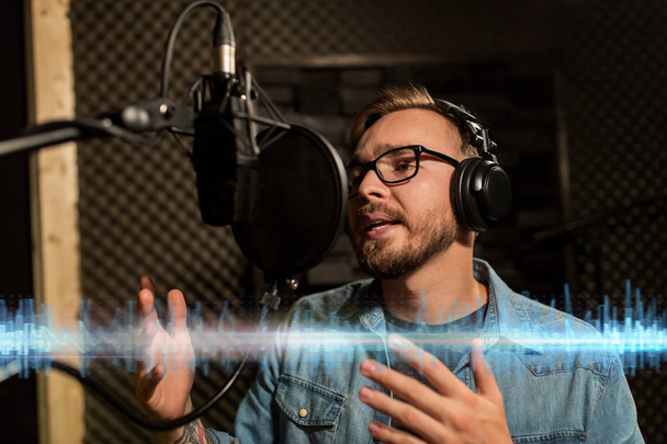 man with headphones singing at recording studio - Fotó, kép