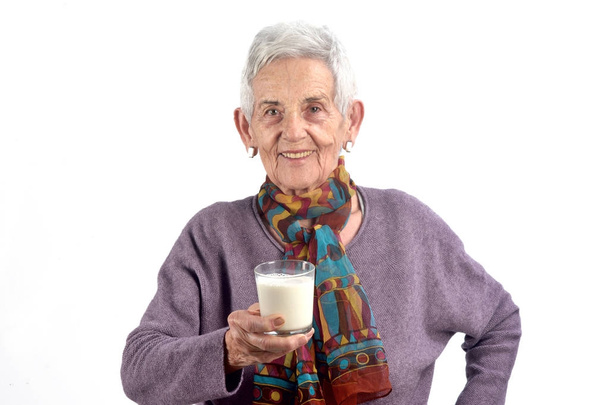 donna anziana bere latte su sfondo bianco
 - Foto, immagini
