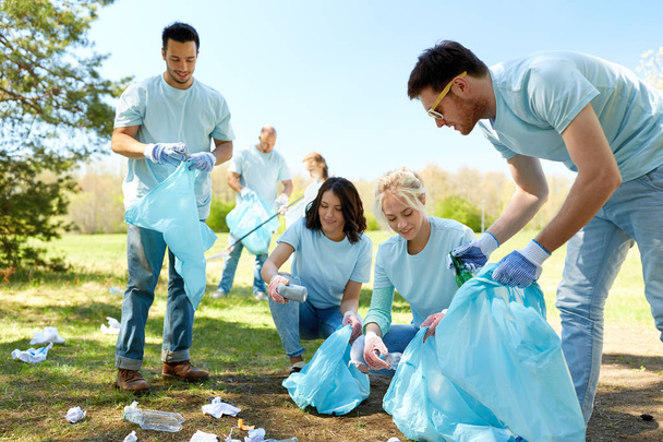 volunteers with garbage bags cleaning park area - Foto, Imagen