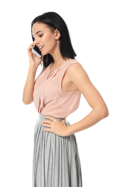 Beautiful young woman speaking by mobile phone on white background - Φωτογραφία, εικόνα