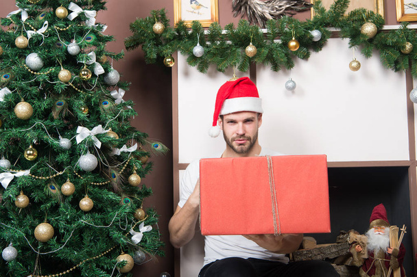 Man with present box at Christmas tree - Foto, afbeelding