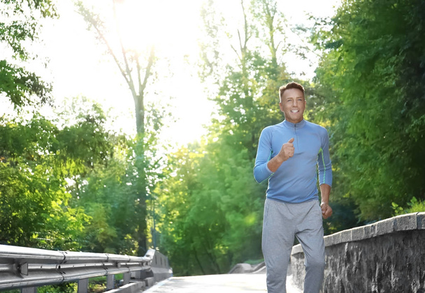 Mature sporty man running outdoors - Foto, imagen