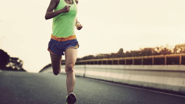jovem mulher fitness correndo na estrada da cidade
 - Foto, Imagem