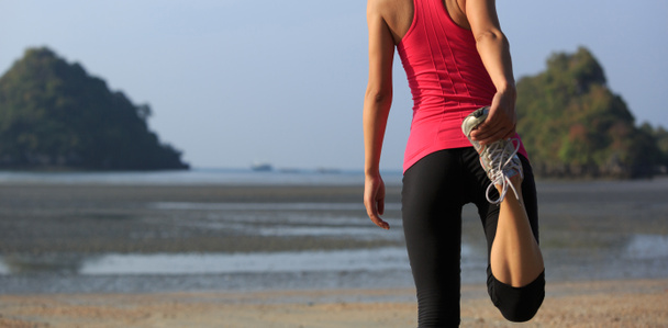Jeune femme fitness échauffement sur la plage de sable
 - Photo, image